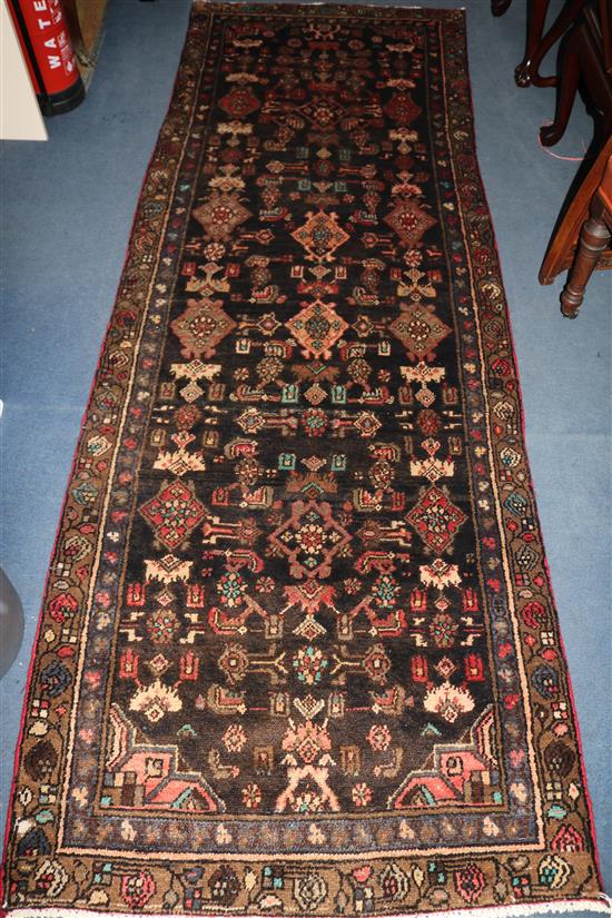 A Hamadan black ground rug, 9ft by 3ft 2in.